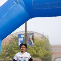 A participant passes the finish line of the Fun(d) run course.